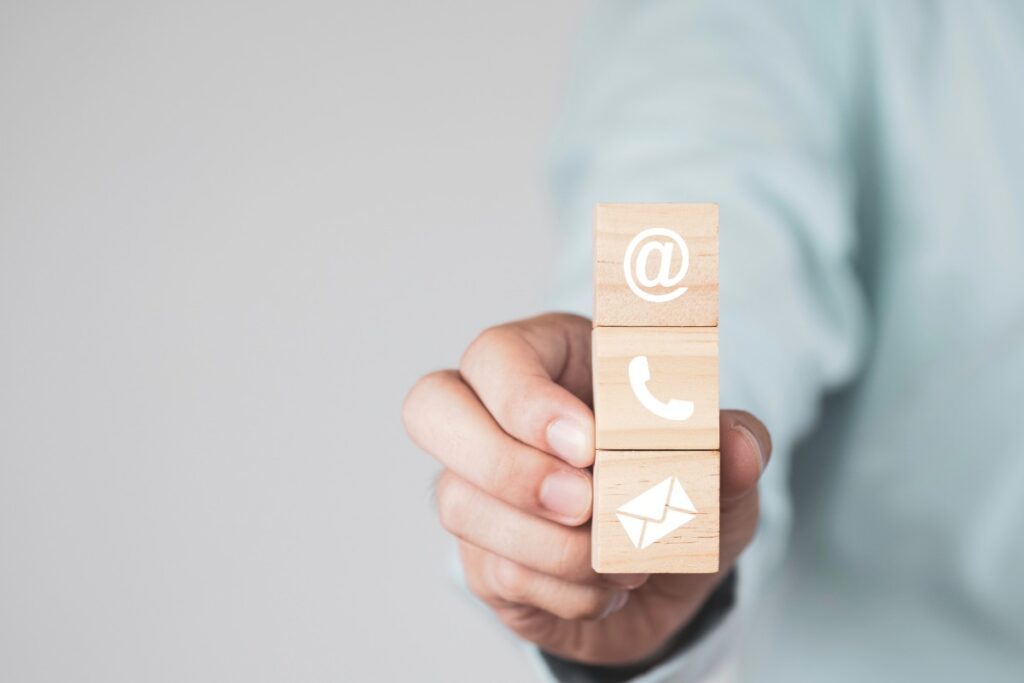 man showing wood blocks symbols email, call and mail