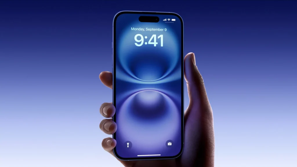 Hand holding iPhone displaying iOS 18 lock screen interface with blue gradient wallpaper.
