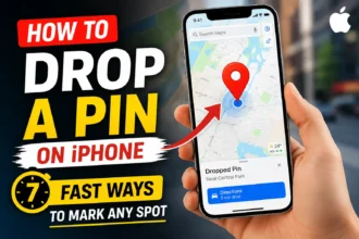 A hand holding an iPhone with Apple Maps open, showing a red location pin and the title about how to drop a pin on iPhone.