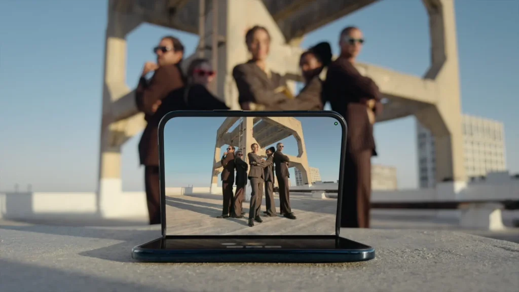 Foldable phone displaying a group photo on an outdoor rooftop